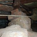 A crawl space support consisting of a rock and wood shimming in a Lansing home