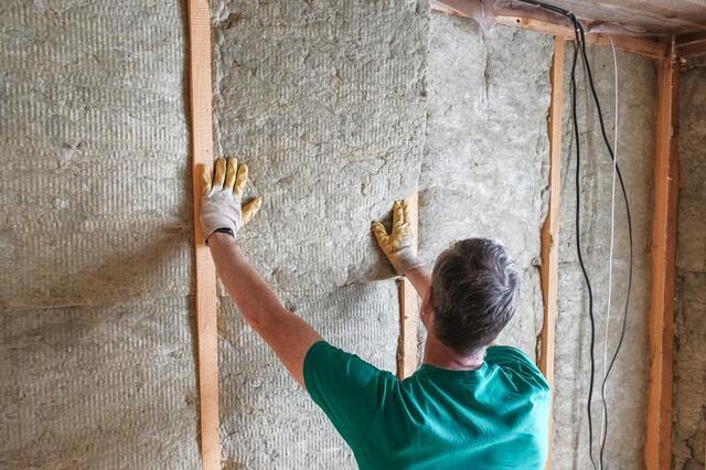 man installing insulation in walls