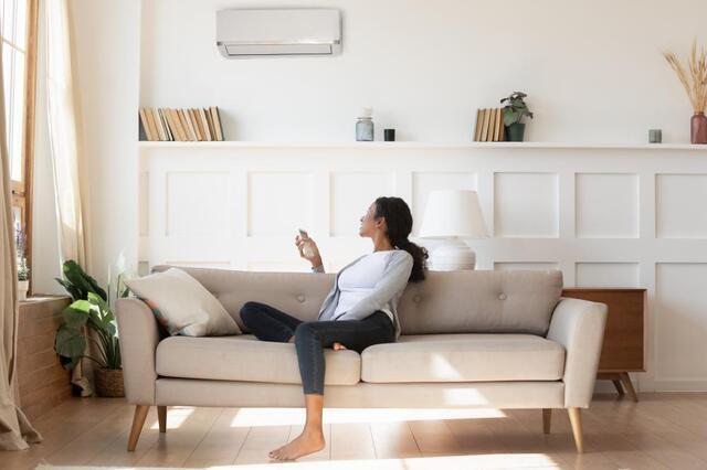 woman sitting on a couch using a heat pump