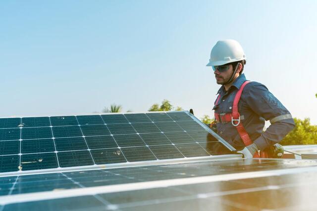 man installing solar panel on a roof