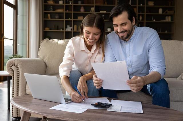 a couple looking at a calculator and receipts